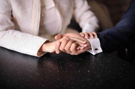 Groom holding bride's hand.