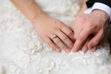 Bride and groom hands on the wedding dress.の写真素材