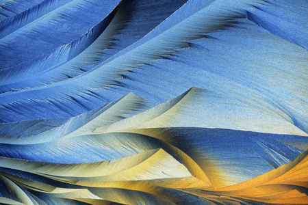 Photo through a microscope of crystals growing from the melt of sulfur. Polarized light technology.