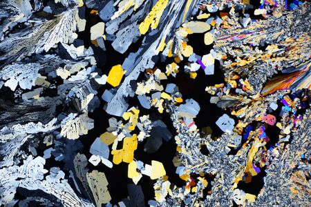 Photo through a microscope of crystals grown from a melt of citric acid. Polarized light technology. Abstract art wallpaper. Background for design.の写真素材