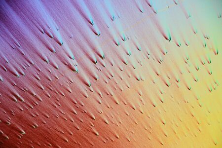Photo through a microscope of crystals grown from a solution of ascorbic acid in alcohol. Polarized light technology. Abstract art wallpaper. Background for design.の写真素材