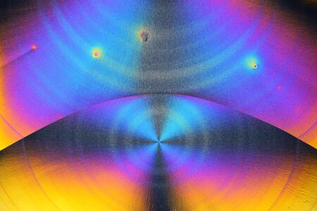 Photo through a microscope of crystals grown from a solution of ascorbic acid in alcohol. Polarized...