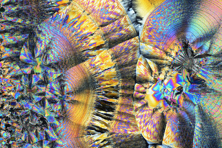 Colorful micro crystals in polarized light. Photo through a microscope.