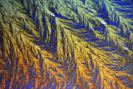 Colorful micro crystals in polarized light. Photo through a microscope.