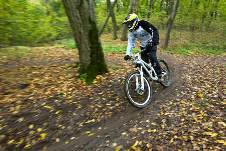 UKRAINE, KIEV - OCTOBER 16: Unknown professional biker with blurred background making his road, at the professional bicycle downhill final competition Kyiv Cup, on October 16, 2011 at Ukraine, Kiev.のeditorial素材