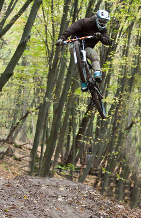 UKRAINE, KIEV - OCTOBER 16: Unknown professional biker with blurred background making his road, at the professional bicycle downhill final competition Kyiv Cup, on October 16, 2011 at Ukraine, Kiev.のeditorial素材