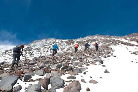 Hikers moving on volcano land in Kamchatka, Russia.