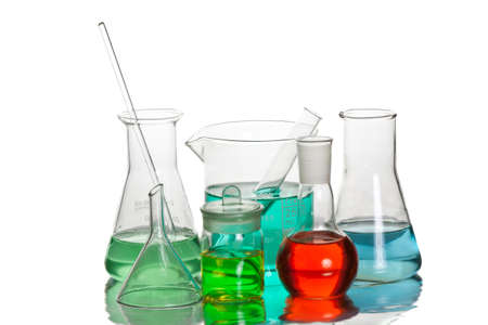 Volumetric laboratory glassware containing colored liquids isolated over white background