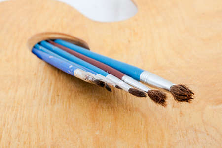 Paintbrushes on palette, isolated on white background.