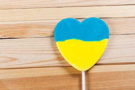 Lollipop with color of ukrainian flag, on wooden background.の写真素材