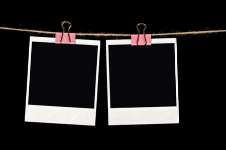 Black instant photo, hanging on the clothesline, isolated on black background.の写真素材