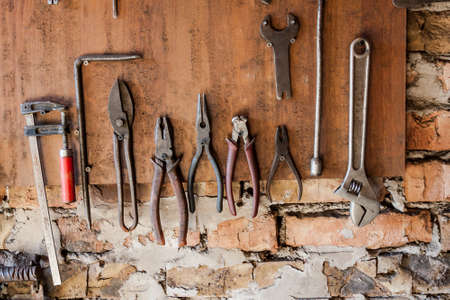 Old vintage tools hanging on a wooden clipboard, hobby time in garage.の写真素材