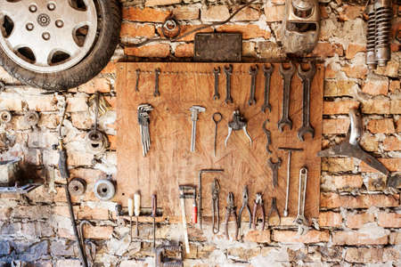 Old vintage tools hanging on a wooden clipboard, grunge background.の写真素材