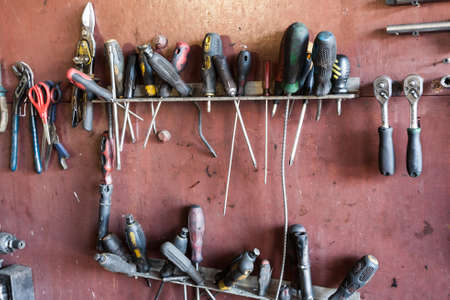 Tools hanging on a wooden clipboard, hobby time in garage.