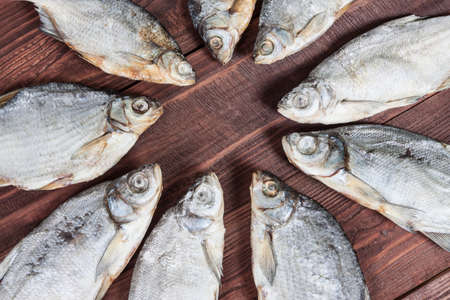 Dried fish on a wooden background, traditional russian snack for a beer.の写真素材