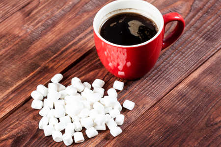 Cup of hot coffee with marshmallows on wooden table.の写真素材