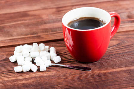Cup of hot coffee with marshmallows on wooden table.の写真素材
