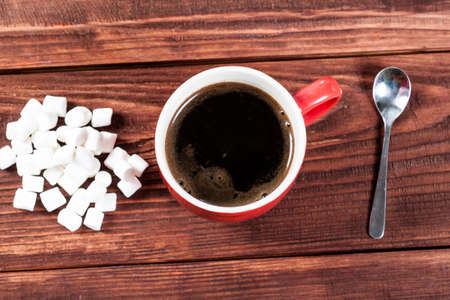 Cup of hot coffee with marshmallows on wooden table.の写真素材
