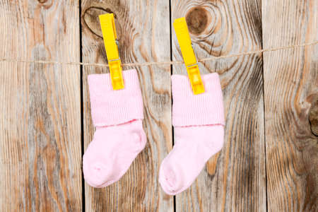 Knitted babies socks on a wooden background.の写真素材
