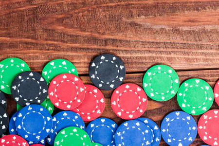 Poker chips over old wooden table. Frame of poker chips. Casino background.