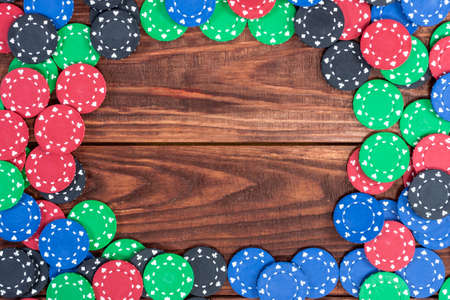 Poker chips over old wooden table. Frame of poker chips. Casino background.の写真素材