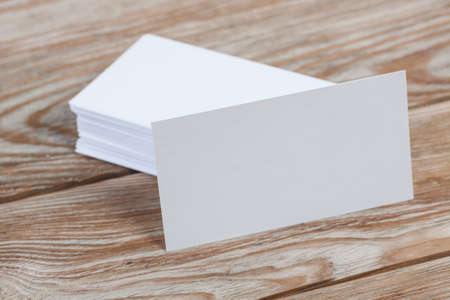 White blank business visit card, gift, ticket, pass, present close up on wooden background. Copy...
