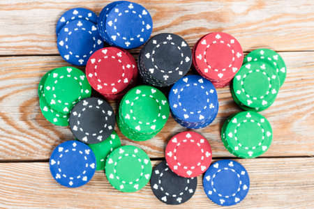 Poker chips over old wooden table. Group of different poker chips. Casino background.の写真素材