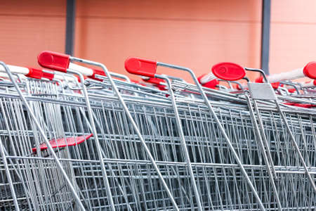 Rows of shopping carts near entrance of supermarket. World consumption problem.の写真素材
