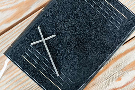 Silver christian cross on bible. Religious concept.