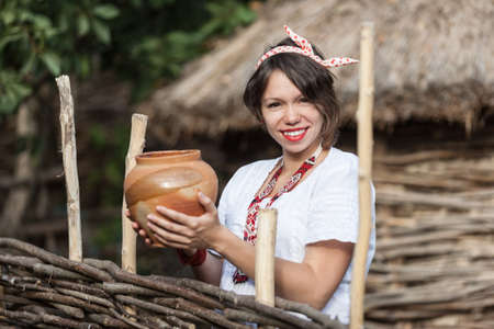 Ukrainian pregnant woman wear traditional embroidered shirt. Location in traditional ukrainian village. Pregnancy concept.の写真素材