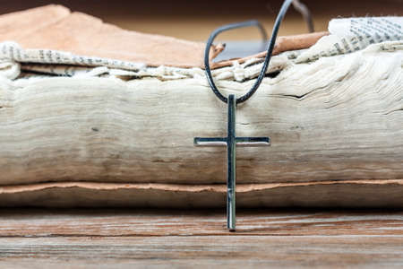 Silver Christian cross on bible. Religious symbols concept.