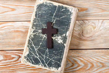 Wooden Christian cross on bible. Religious symbols concept.