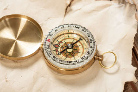Old map with compass on old wooden background.