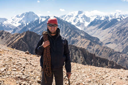 Hiker relaxing on top of a mountain and enjoying valley view. Tien Shan mountains, central asia, Kyrgyzstan.の写真素材
