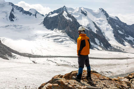 Hiker relaxing on top of a mountain and enjoying valley view. Tien Shan mountains, central asia, Kyrgyzstan.の写真素材
