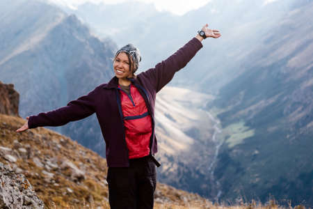 Hiker relaxing on top of a mountain and enjoying valley view. Tien Shan mountains, central asia, Kyrgyzstan. Climbing and mountaineering concept.の写真素材