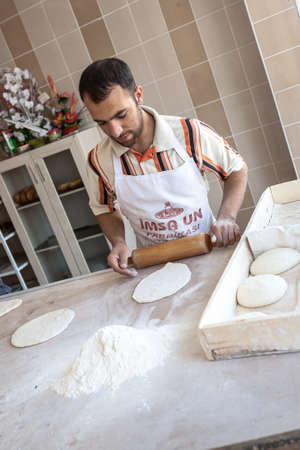 Adiyaman, Turkey - September 17, 2011: An unknown baker in a traditional Turkish bakery, making hand-made bread cooked on fire.のeditorial素材