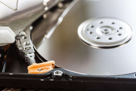 Close view of open hard disk drive with spindle. Electronic devices and technology concept.