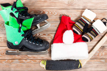 Overhead view of hockey ice skates accessories placed on old rustic wooden table. Items included...