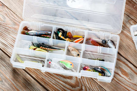 View of fishing accessories on white wooden table. Set of wobblers of different colors and different purposes.の写真素材