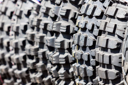 Stack of motorcycle tires outside.