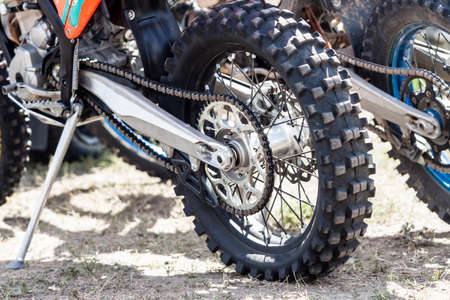 Close-up of muddy rear wheel and engine of dirt motorcycle details. Extreme sport competition.の写真素材