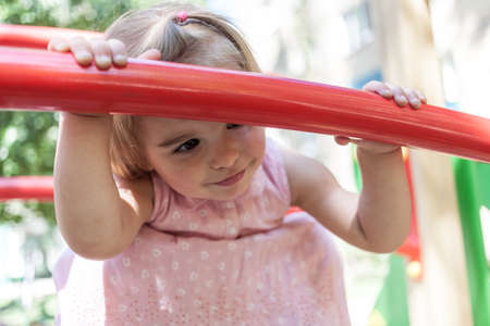 Active little girl having fun on a children playground.の写真素材