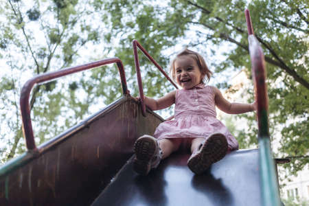 Active little girl having fun on a children playground.の写真素材