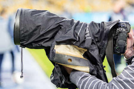 Professional photographer using his gear during football match.の写真素材