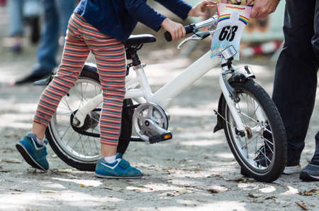 View on cute boy riding his bike. Child on bicycle in the park.の写真素材