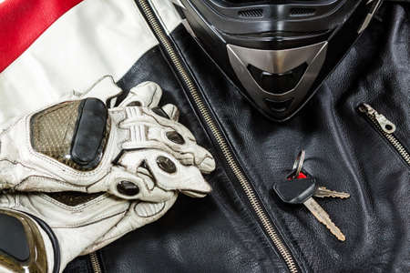 View of motorcycle rider accessories. Items included motorcycle helmet, gloves, keys and jacket. Motorcycle travel dream concept.の写真素材