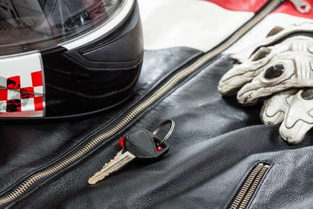View of motorcycle rider accessories. Items included motorcycle helmet, gloves, keys and jacket....