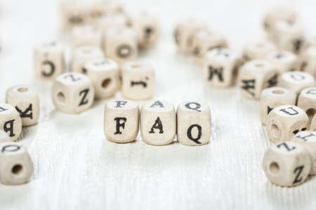 Word FAQ formed by wood alphabet blocks. On old wooden table.の写真素材