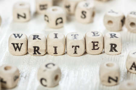 Word WRITER formed by wood alphabet blocks. On old wooden table.の写真素材
